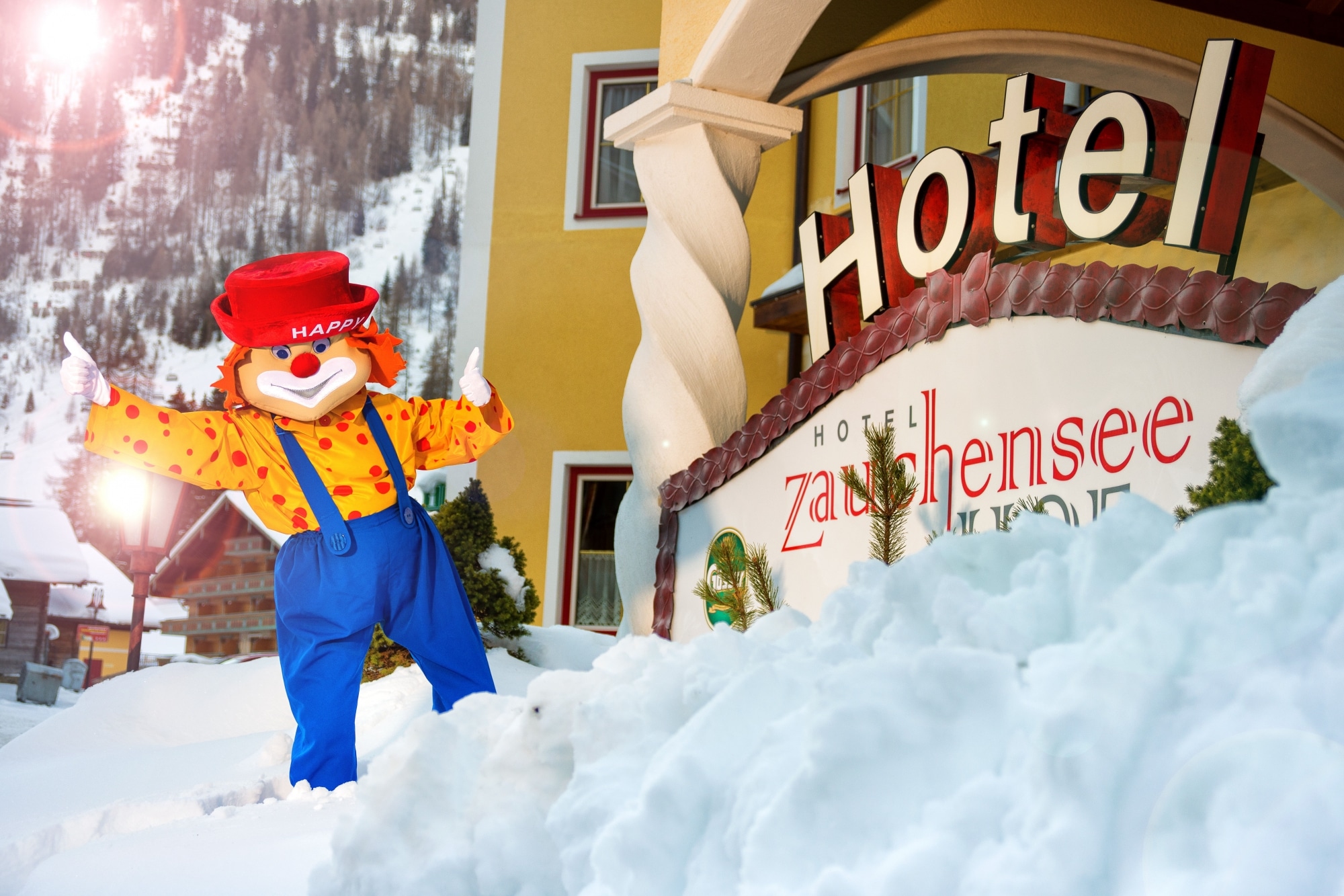 Maskottchen "Happy" vor dem verschneiten Hotel Zauchenseehof