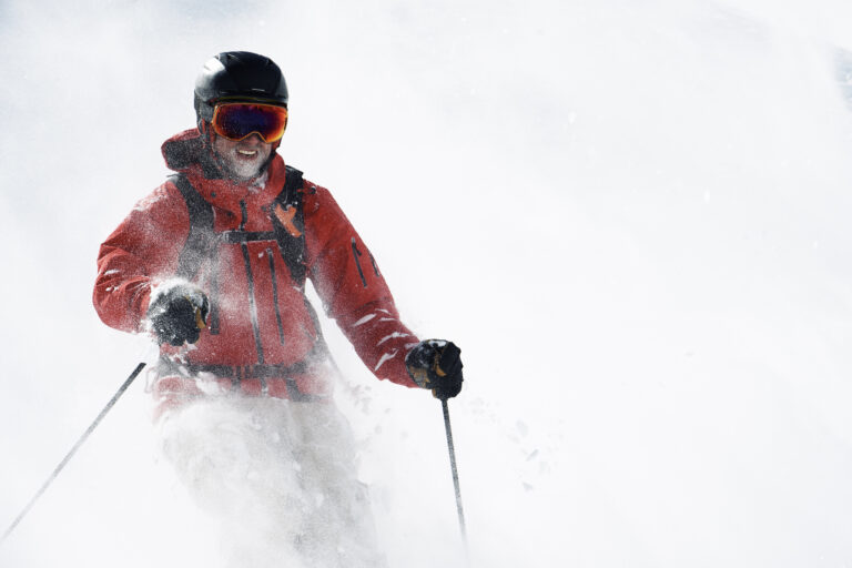 Male skier covered in powder snow on mountainside Alpe-d'Huez, Rhone-Alpes, France