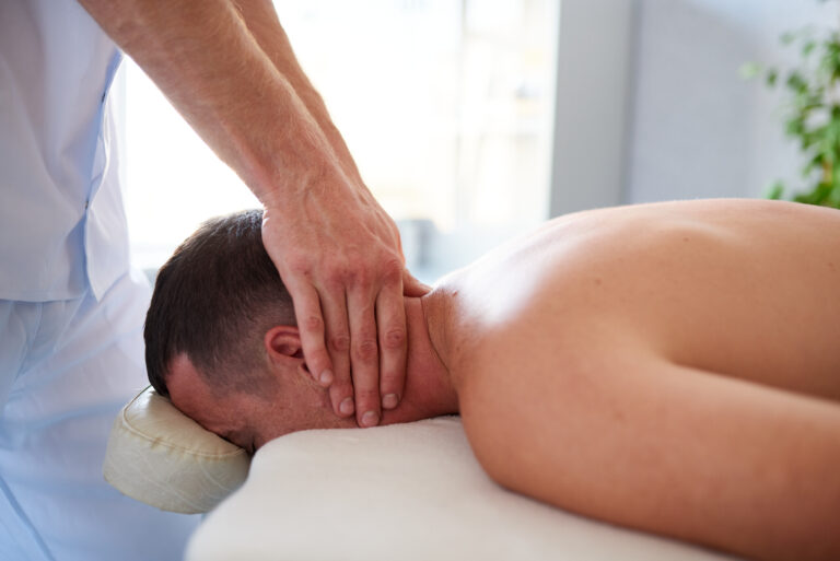 Neck massage in therapist's cabinet on a table, side view