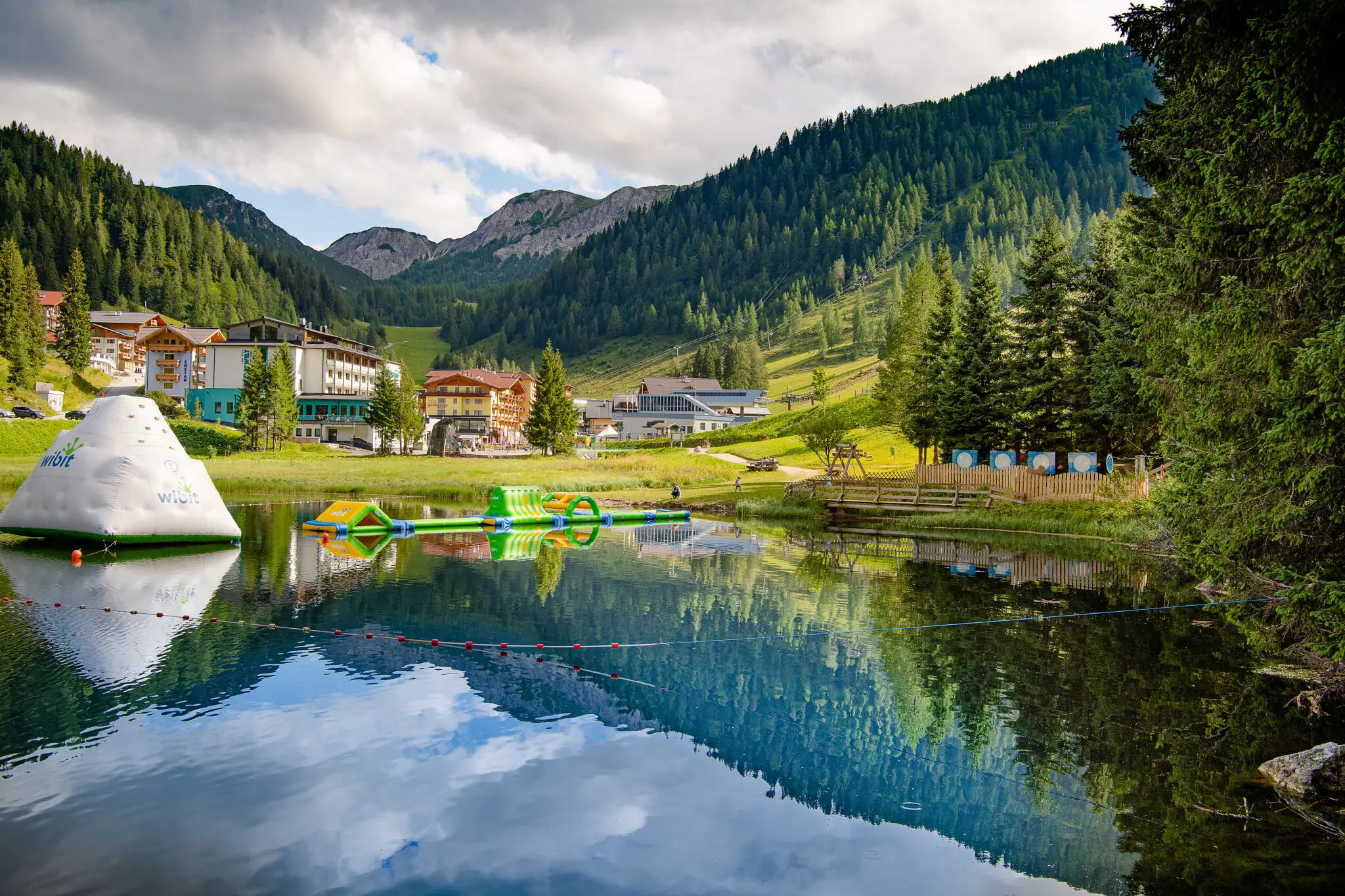 Ruhiger See mit reflektierenden Bergen und Freizeitger&auml;ten im Salzburger Land. Familienhotel Zauchenseehof