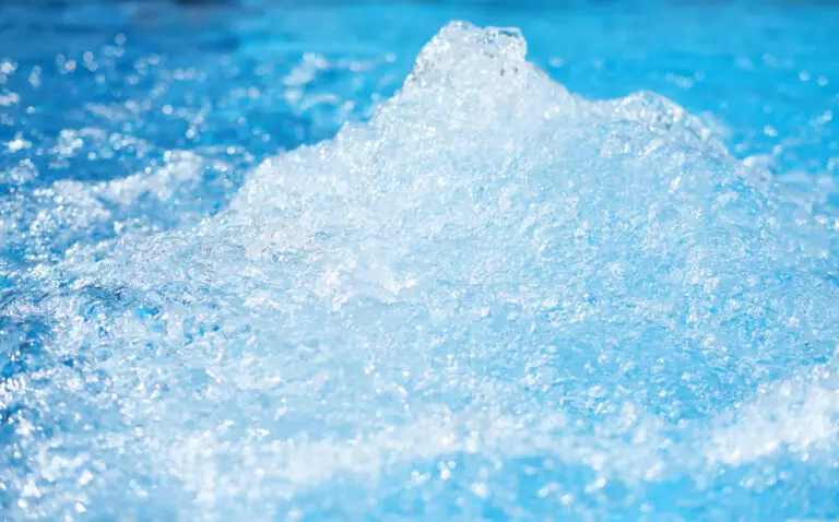Sprudelndes, klares Wasser in einem Whirlpool mit Blasen und Wellen.