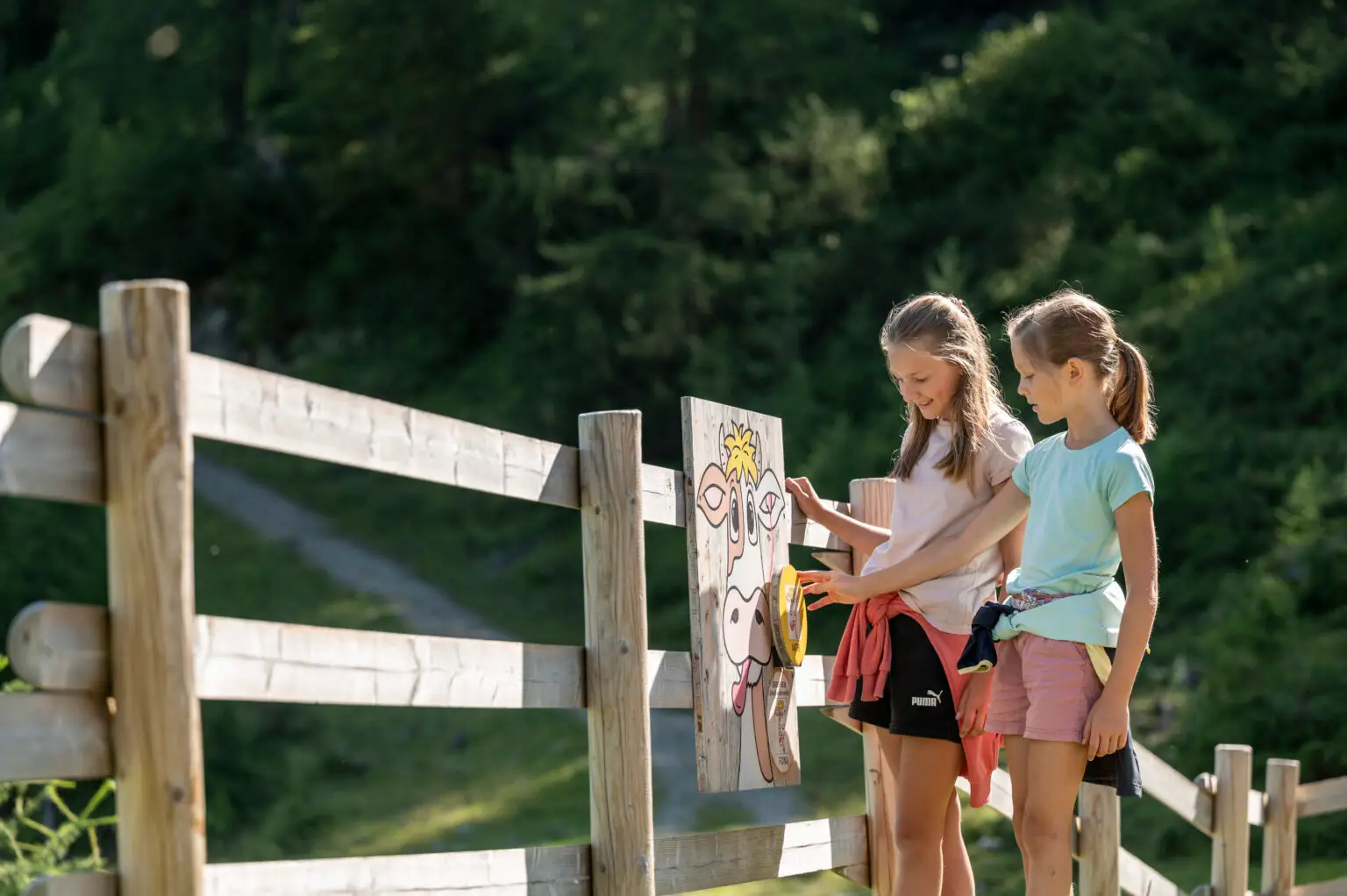 Zwei Mädchen lösen an einer Spielstation des Erlebnisbergs Gamskogel in Altenmarkt-Zauchensee gemeinsam eine Aufgabe. Familienhotel Zauchenseehof Salzburger Land